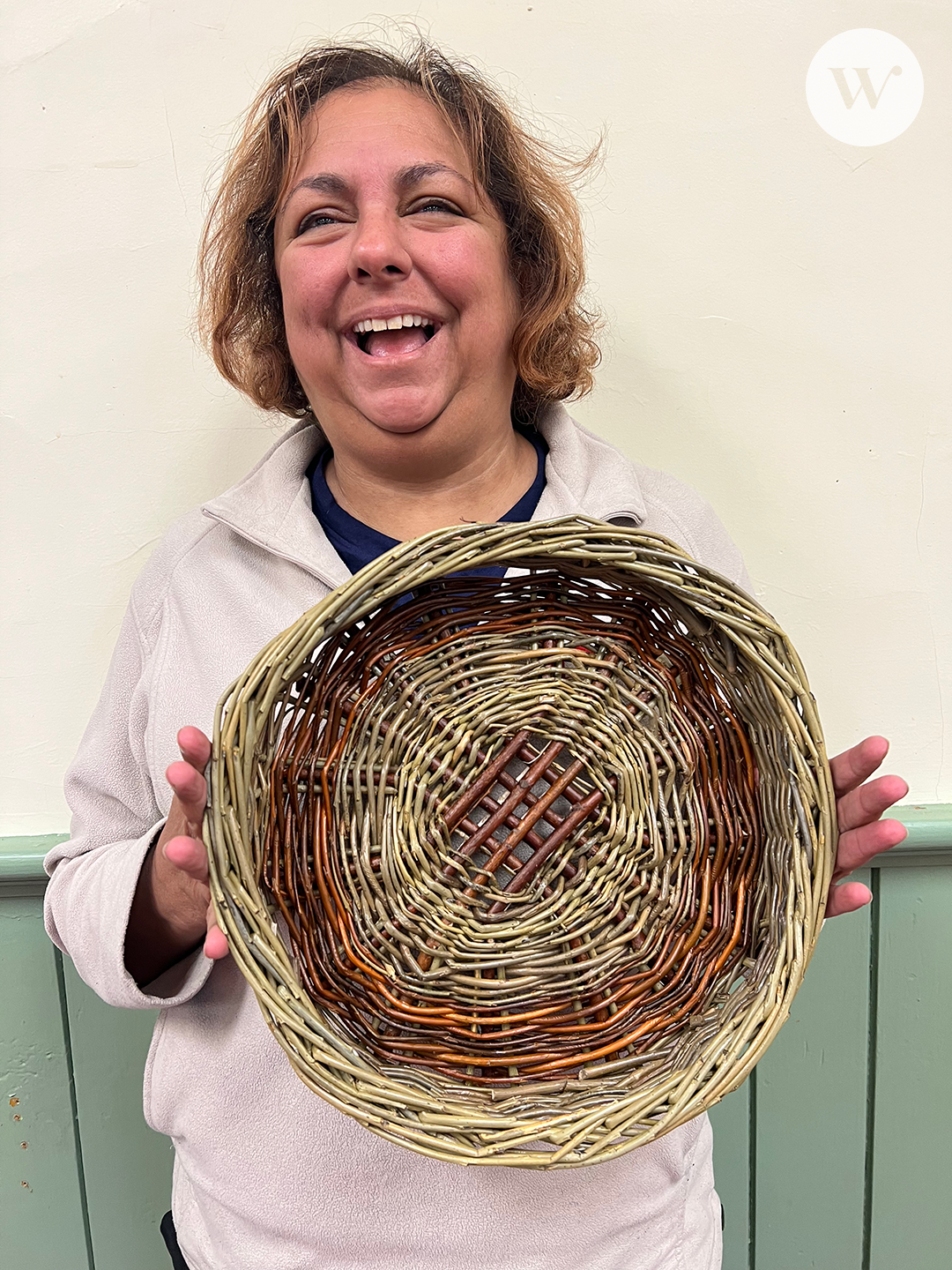 A photograph of one of our class participants showing the bowl she created. She's smiling and seems very pleased with the results.